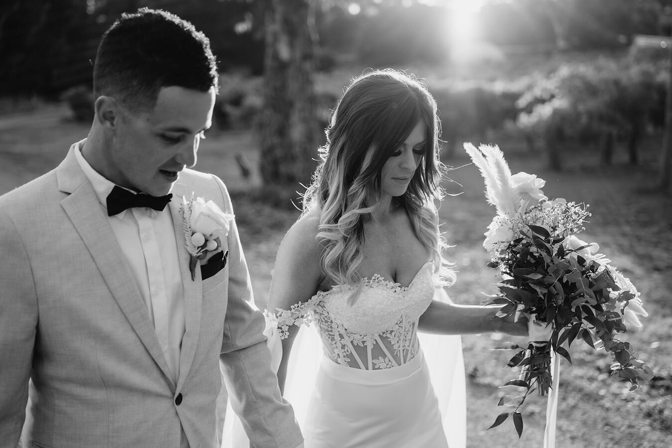 A bride and groom walking together after getting married in black and white.
